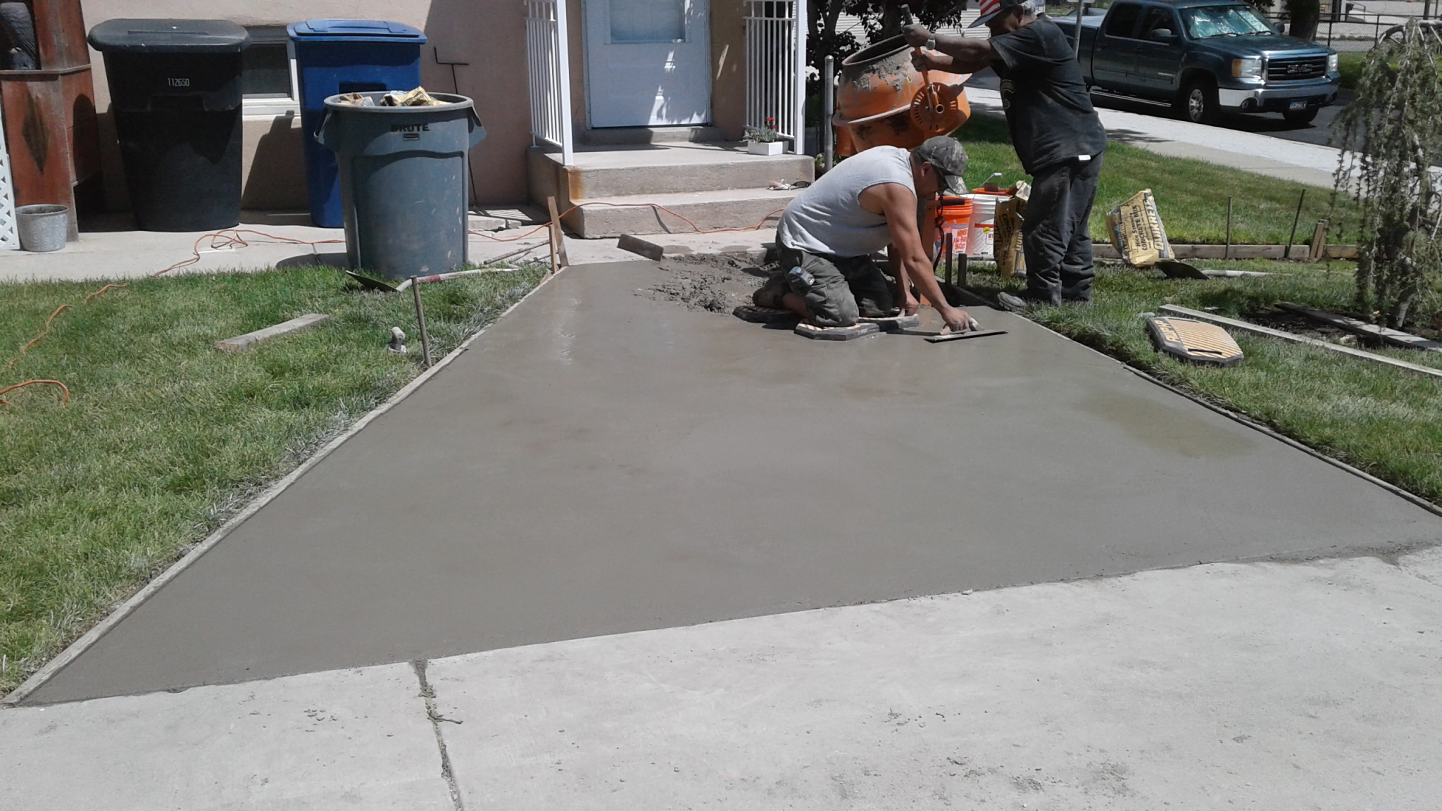 A couple of men working on a cement slab