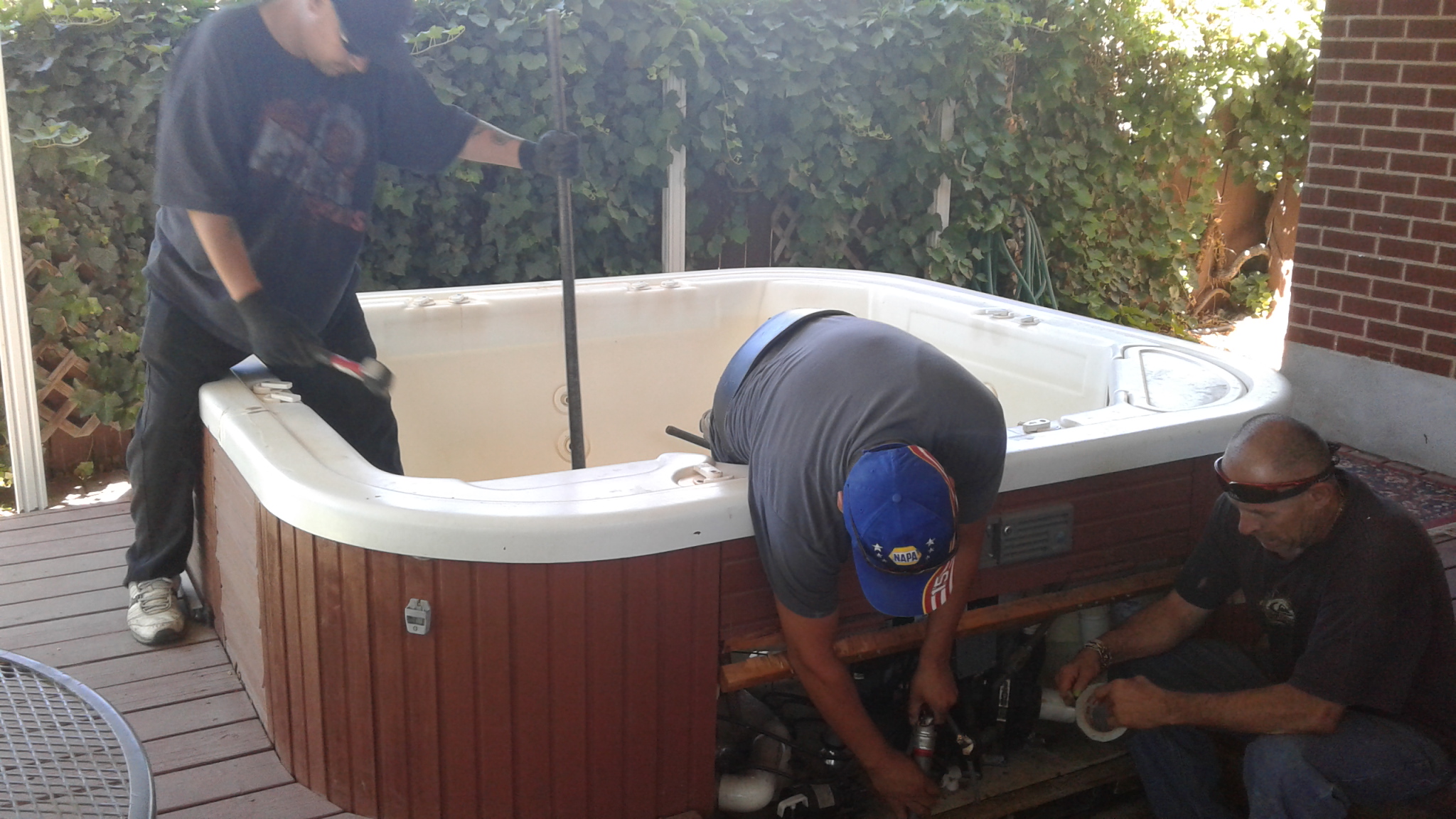 A couple of men working on a hot tub