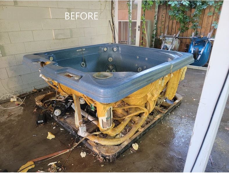 A blue and yellow bath tub sitting on top of a wooden pallet