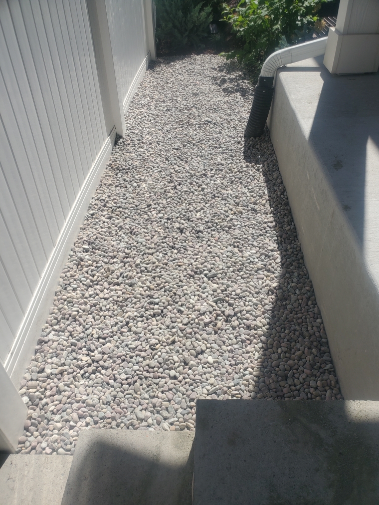 A walkway made of rocks and gravel next to a house