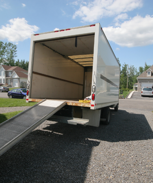 A white truck with a ramp attached to the back of it